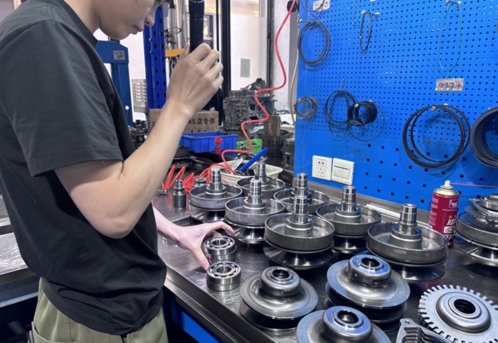 Technician inspecting CVT pulley sets on the workshop bench